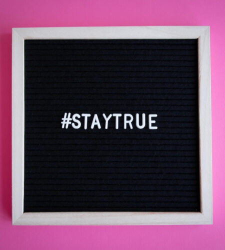 Bild an der lila Wand mit dem Schriftzug stay true